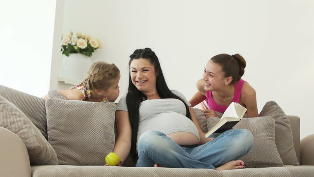 Happy pregnant woman and her daughters