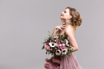 Beautiful woman with bouquet in pink dress.