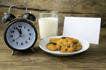 cookies and a glass with milk with a white note for santa