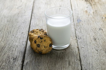 cookies and a glass with milk on wooden table
