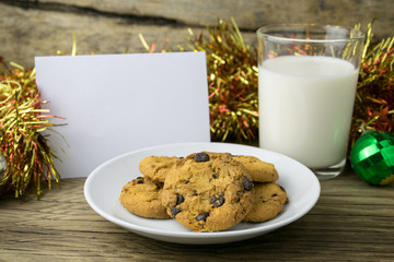 cookies and a glass with milk with a white note for santa
