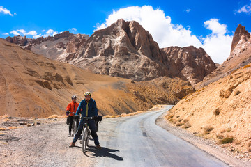 Fototapeta premium Two cyclist standing on mountains road. Himalayas, Jammu and Kashmir State, North India