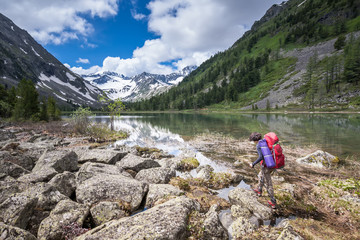 Young woman is hiking in highlands of Altai mountains, Russia