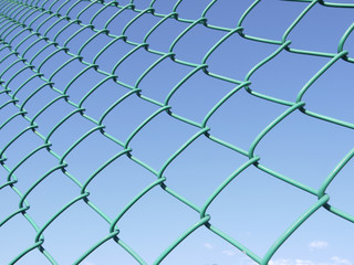 Fototapeta premium closeup Green seamless fence chain, Iron wire fence on blue sky background