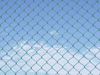 Green seamless fence chain, Iron wire fence on blue sky background