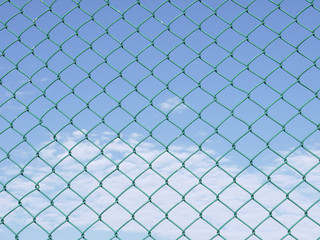 Fototapeta premium Green seamless fence chain, Iron wire fence on blue sky background