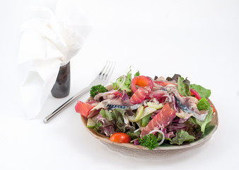 Mixed salad with dressingand greenery isolated on white