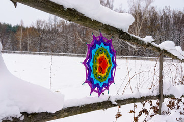 Wicker mandala on a fence in the winter in nature.