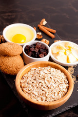 butter, cereal and ingredients for baking cookies on black table