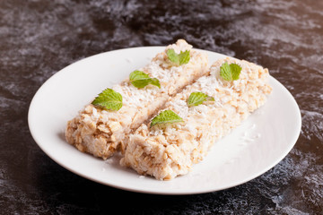 oat bar with coconut with mint on a plate, close up