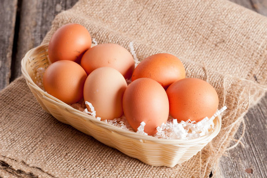 Eggs in Wicker basket on a wooden background
