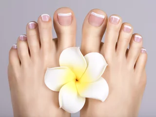 Foto op Canvas female feet with white french pedicure on nails. at spa salon © Valua Vitaly