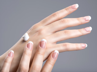 Obraz na płótnie Canvas Close-up female hands apllying hand cream
