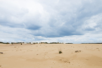 Cloudy blue sky above sand dunes