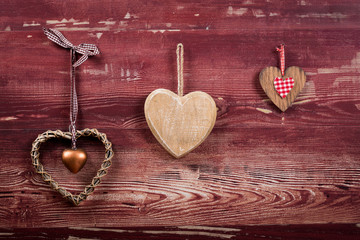 trois cœurs en bois sur planche rouge