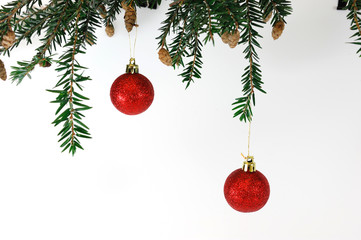 hanging Christmas baubles on pine branch