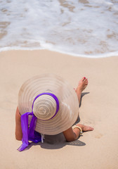 woman with straw hat on the beach