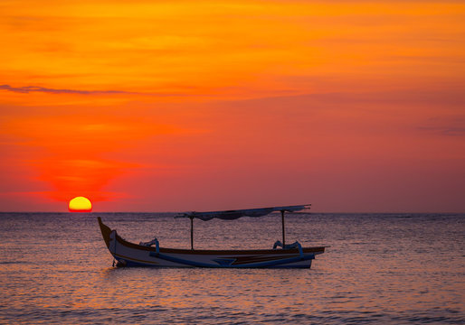 Images of the Sun setting with fishing boats