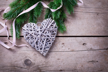 Spruce branches  and rustic  Christmas heart  on  vintage  woode