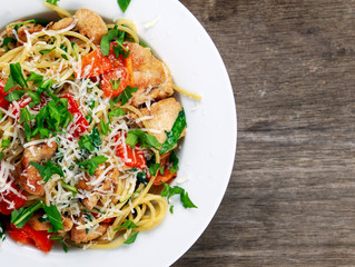 Italian Chicken Breast spaghetti with red pepper, Parmesan cheese and wild rocket  lives. on old wooden table.