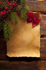 Blank paper sheet, red bow and branch of spruce tree