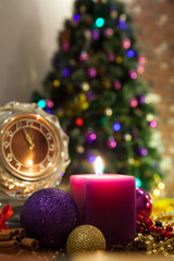 Candle, old clock and Christmas balls with winter decoration