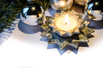 Brennende Kerze mit Christbaumkugeln