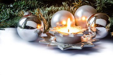 Brennende Kerze mit Christbaumkugeln