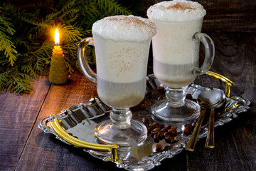 Cappuccino with a decorated Christmas tree on a wooden table