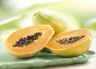 Whole and halved sweet fresh papaya