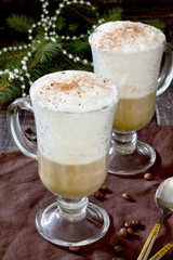 Cappuccino with a decorated Christmas tree on a wooden table