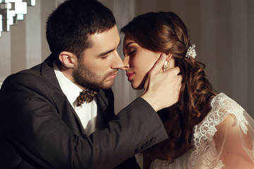 beautiful couple, groom and bride wear wedding clothes,embracing  in bedroom