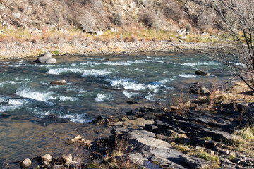 Fototapeta na wymiar Animas river with rapids and a slate shoreline