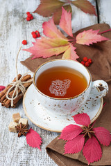 Cup of autumn tea on light  wooden background