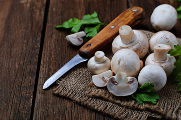 Raw champignon mushroom on wooden background