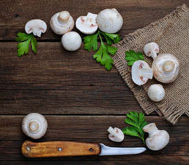 Raw champignon mushroom on wooden background