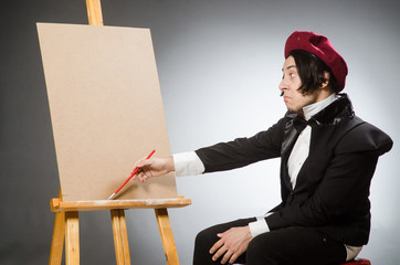 Funny artist in dark studio