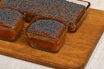 Three lemon poppy cakes on wooden plate