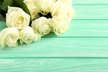 Bouquet of white roses on mint wooden background