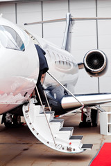 Businessman on the ladder of business jet (airplane)