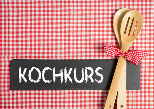 Kochkurs - Kochl&ouml;ffel mit Schiefertafel und Text auf Tischtuch