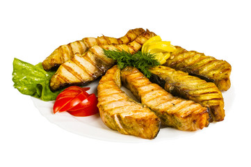 grilled fish with greens on the plate, isolated