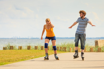 Young couple on roller skates riding outdoors