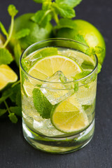 Mojito cocktail with fresh limes, mint and ice, selective focus