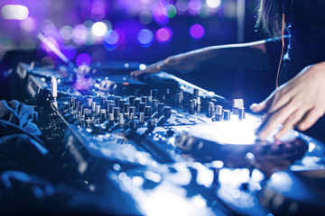 Dj mixes the track in the nightclub.