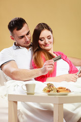 Young couple with tablet and credit card at home