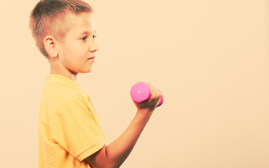 Sports boy making exercise with dumbbell.
