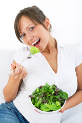 Young woman eating salad