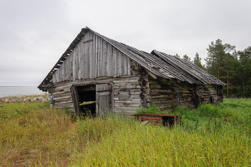 Obraz premium Old abandoned barn log cabin on the beach