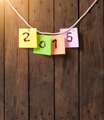 New year 2016 of burned in papernote on a wooden background